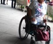 A female DAK amputee sitting in her wheelchair in front of the Vienna AKH*, smoking a cigarette in June 2013.n*AKH = General Hospital