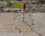 A very short video of a sundial made with stones and a red hot poker flower in a vase while a few shells go about their day&#39;s activities. Watch out for the shell with an insatiable appetite for the minute stones!